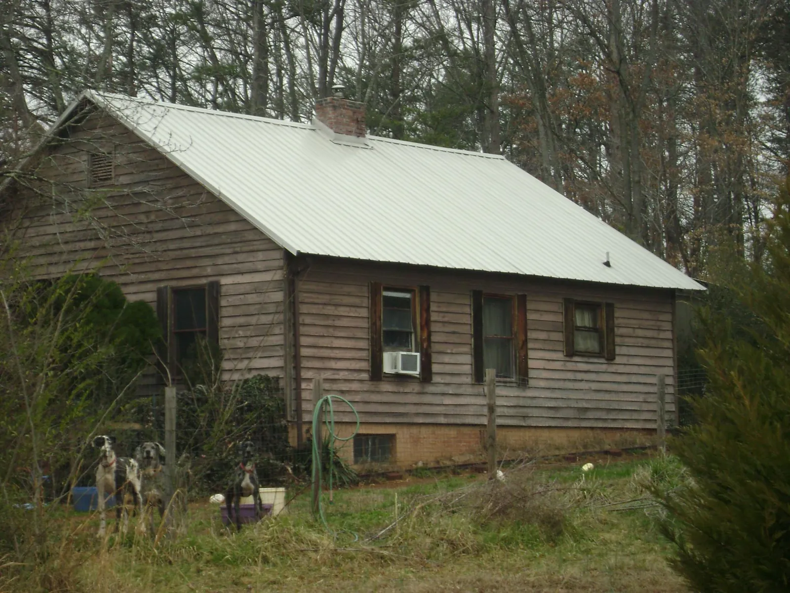 White metal roof on an old wood sided farmhouse, from a Metal Roof Installation job in Cantrall